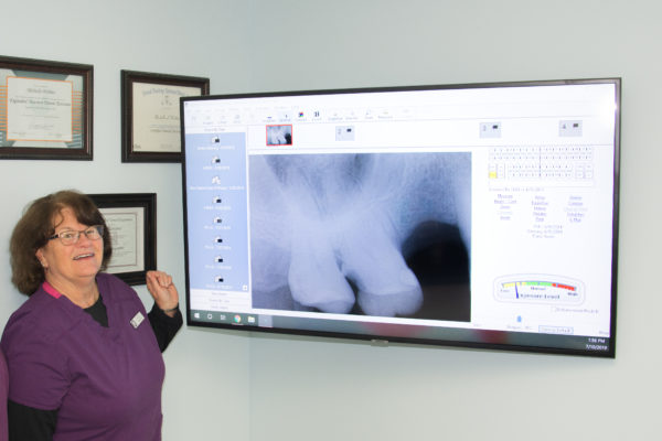 Nellie Clark with Seasons of Smiles Dental reviewing digital x-rays.