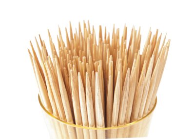 A lot of toothpicks in the cup. On a white background.